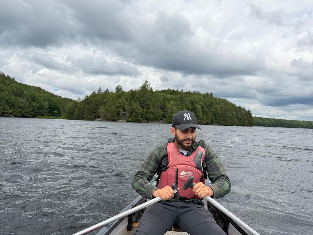 Rowing a canoe across a lake under heavy cloud