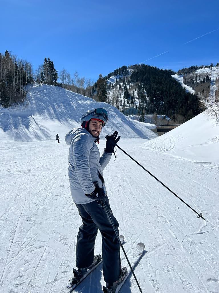 Skiing down a groomed run under a clear blue sky